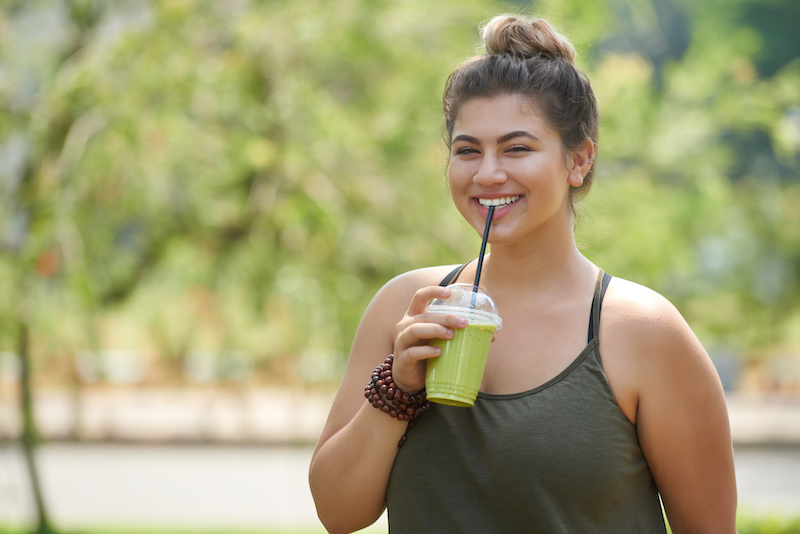 Woman drinking a green smoothie