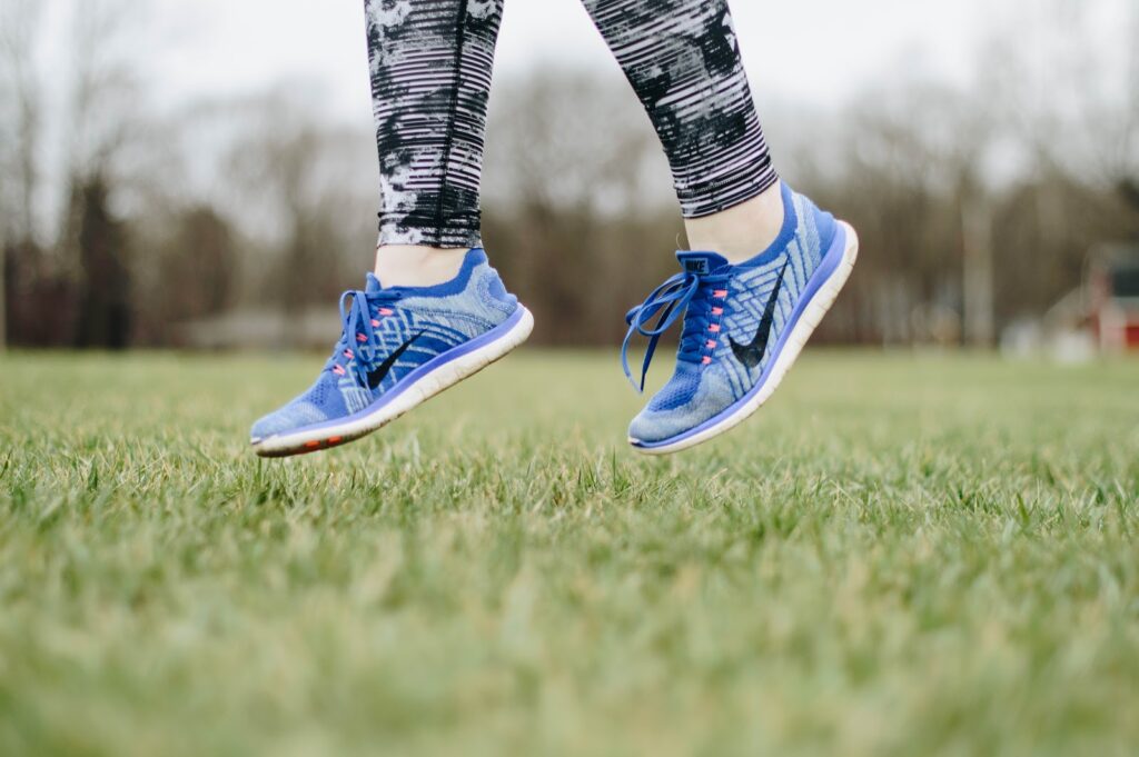 tennis shoes jumping in grass